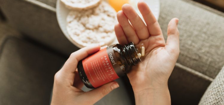 woman holding bottle of probiotics